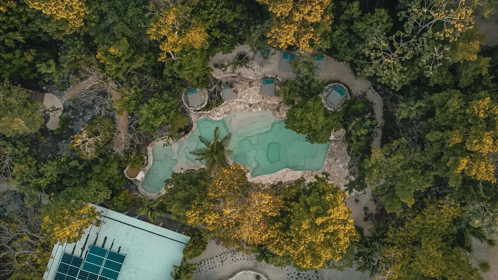 Vista aérea de Pepem Holistic Retreats: albercas de agua de cenote y selva maya en Tulum